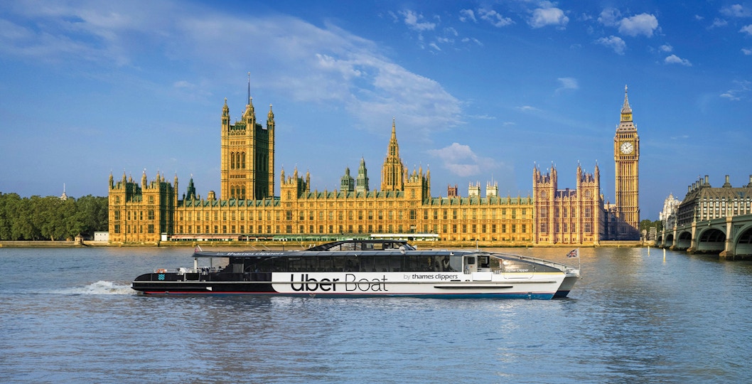 Uber Boat on Thames River passing Westminster Palace, London.