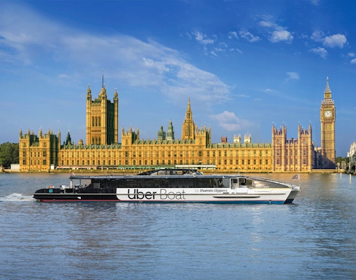 Uber Boat on Thames River passing Westminster Palace, London.