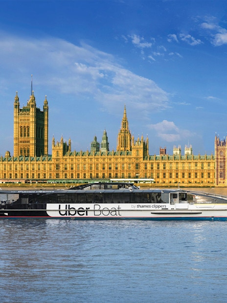 Uber Boat on Thames River passing Westminster Palace, London.