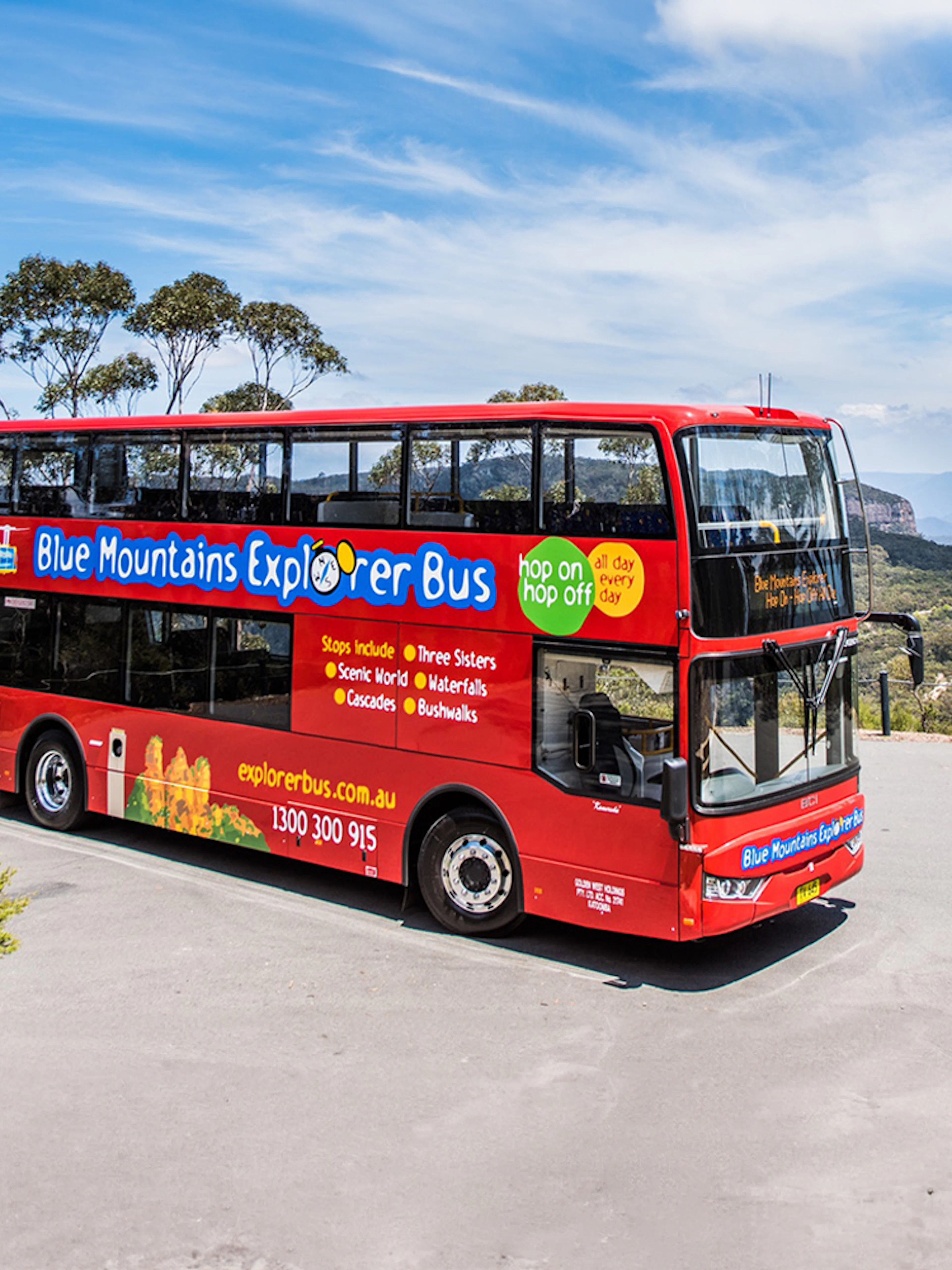 Red double-decker bus on Blue Mountains Hop-On Hop-Off Tour with scenic view.