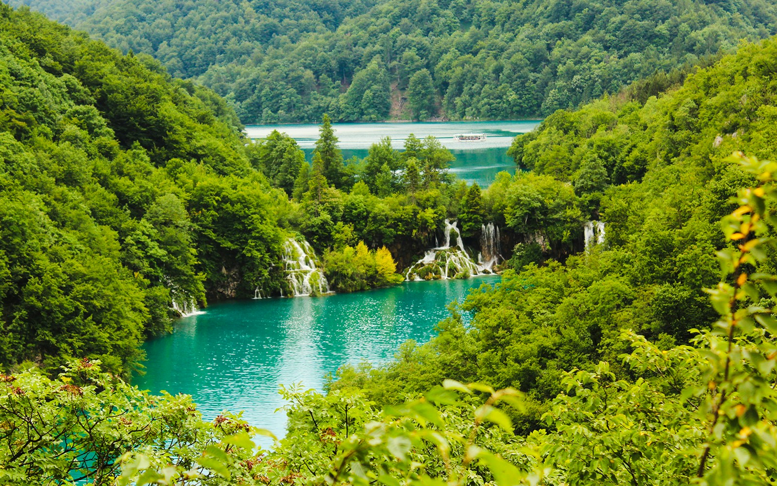 Plitvice Lakes National Park Croatia, cascading waterfalls and turquoise lakes surrounded by lush forest.