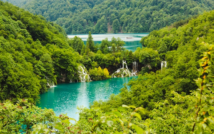 Waterfalls and turquoise lakes surrounded by lush greenery at Plitvice Lakes National Park, Croatia.