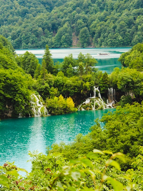 Waterfalls and turquoise lakes surrounded by lush greenery at Plitvice Lakes National Park, Croatia.
