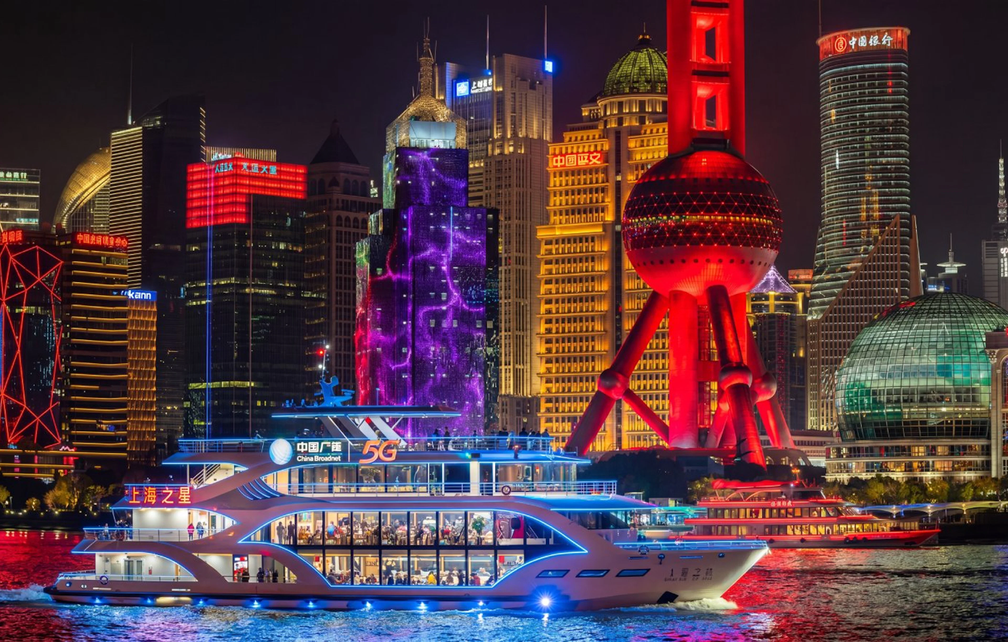 Shanghai skyline at night with illuminated Oriental Pearl Tower and Pudong financial district.