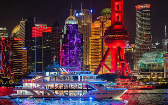 Shanghai skyline at night with illuminated Oriental Pearl Tower and Pudong financial district.