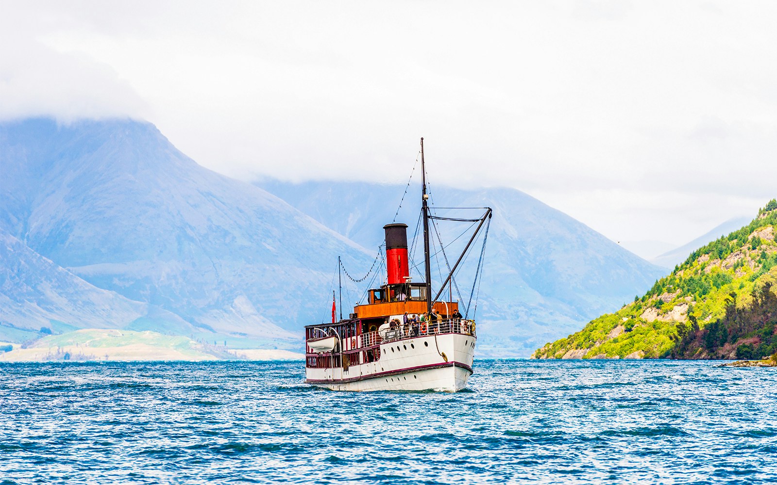 SS Earnslaw steamship moored at Lake Wakatipu with mountains in the background.