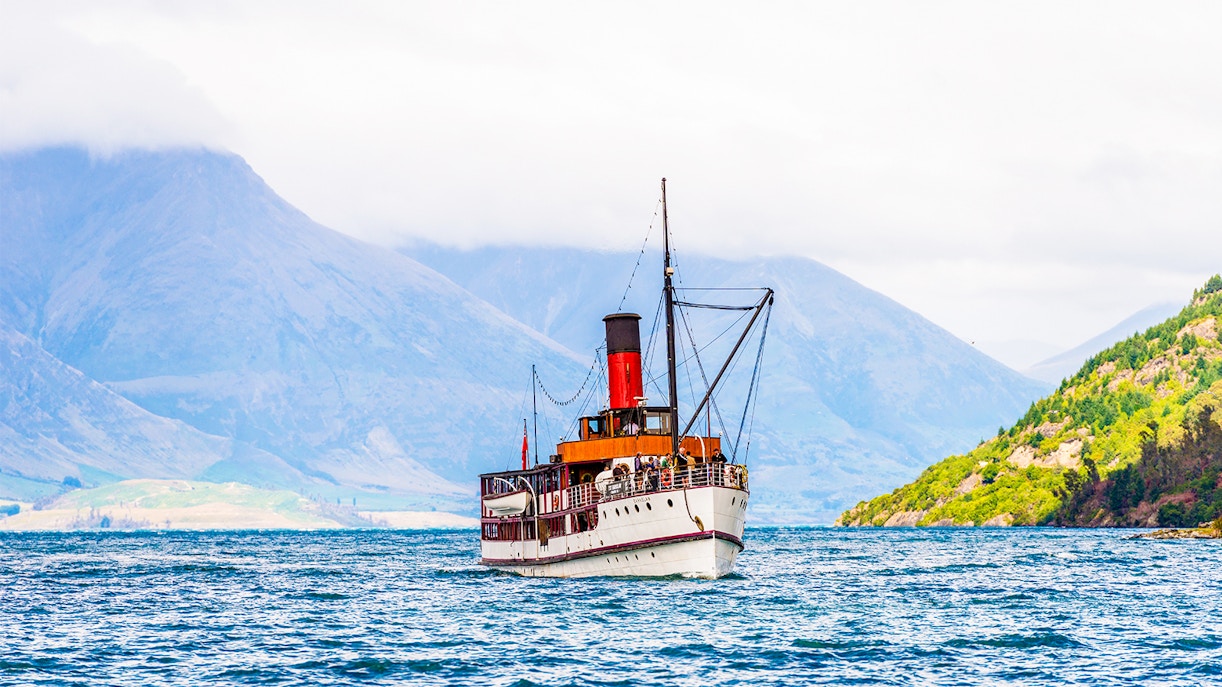 SS Earnslaw steamship moored at Lake Wakatipu with mountains in the background.