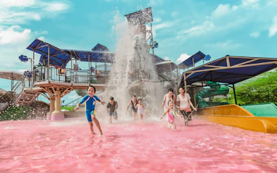 Tourists enjoying pink water pool at Adventure Waterpark Desaru Coast.