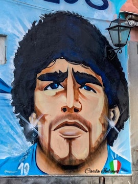 Mural of a famous footballer in Naples, Italy, featured on Maradona Tours.