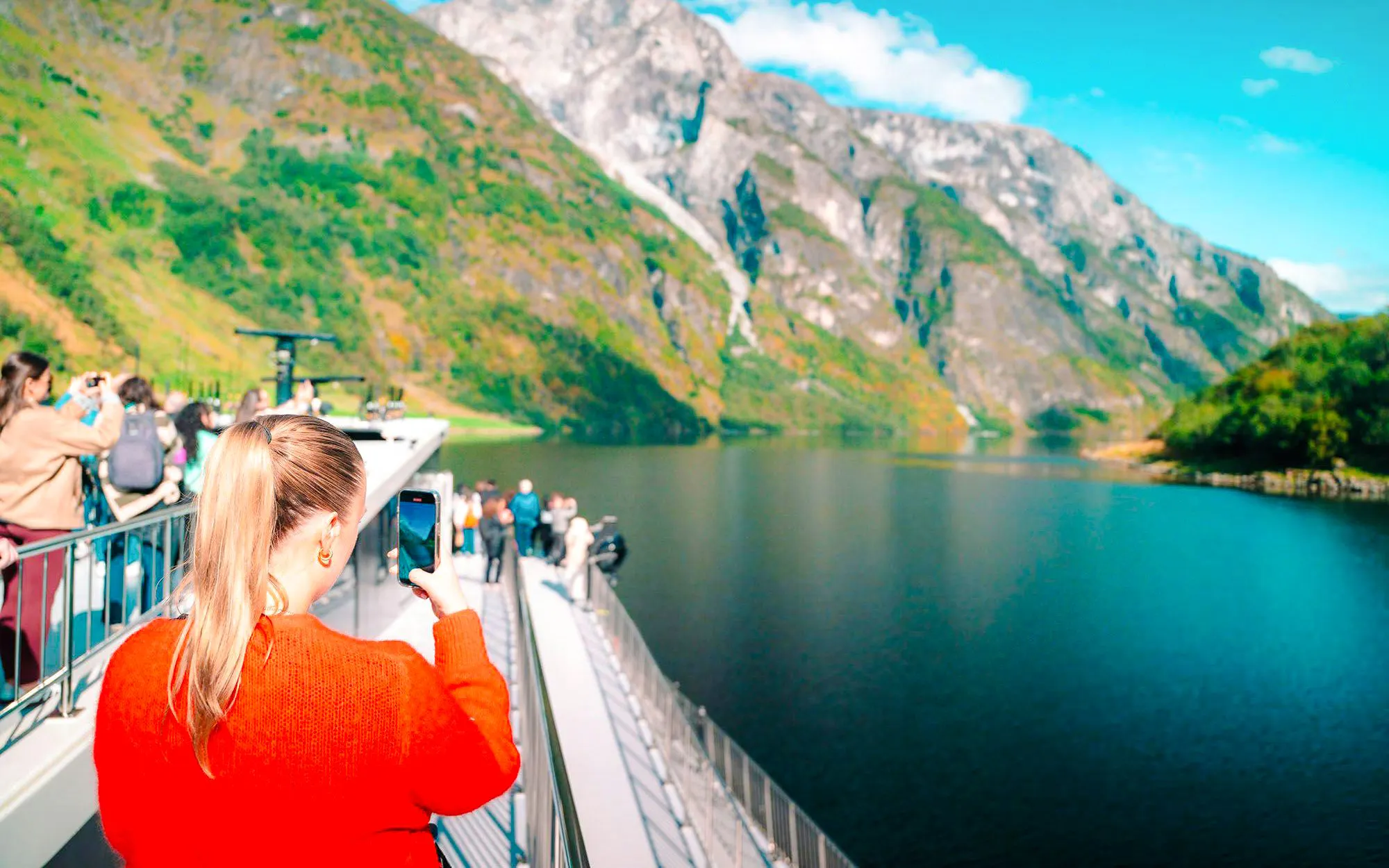 Cruise passengers photographing Nærøyfjord landscape in Norway.