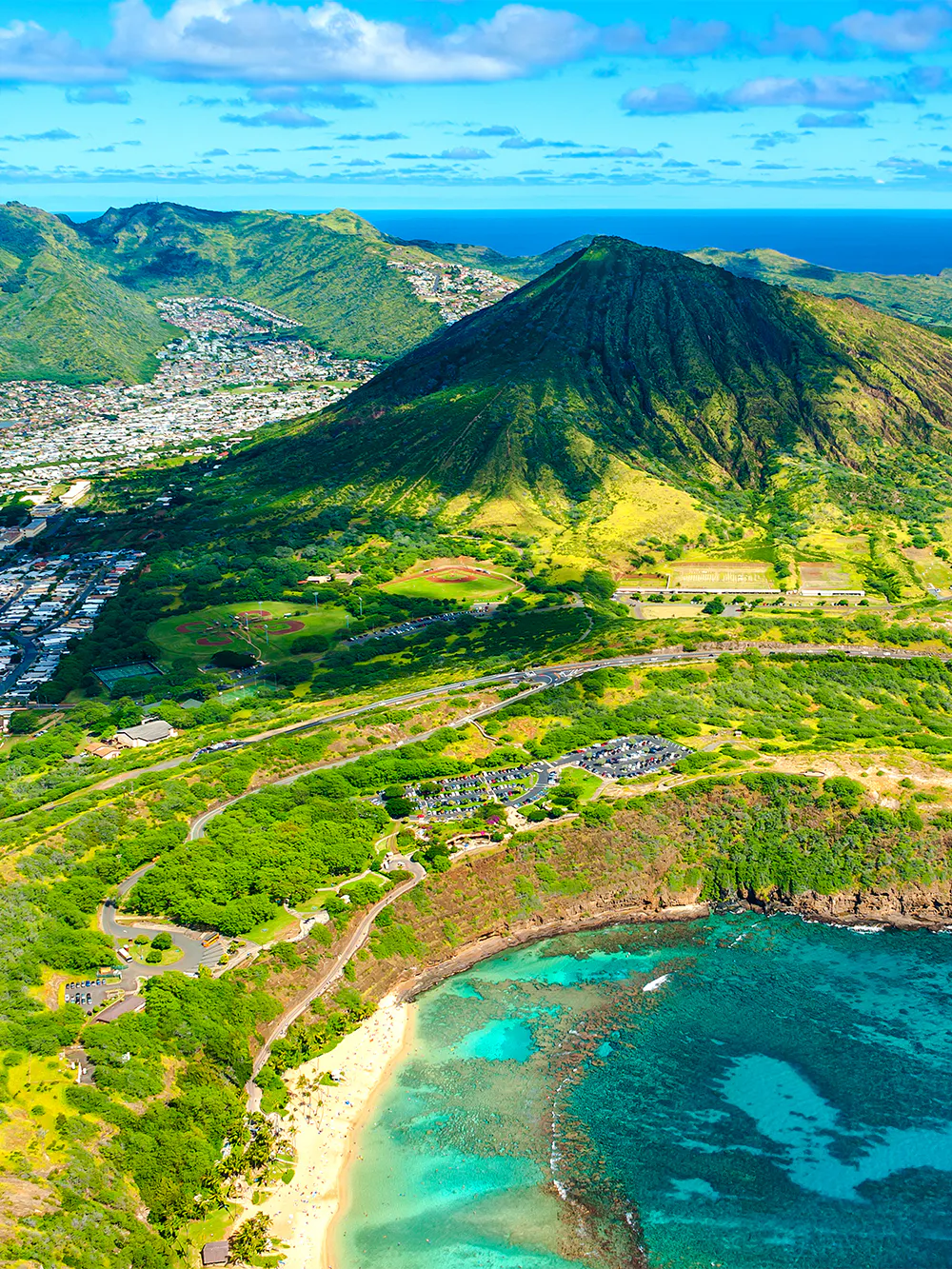 Aerial view of Hanauma Bay, Hawaii, showcasing turquoise waters and lush green hills.