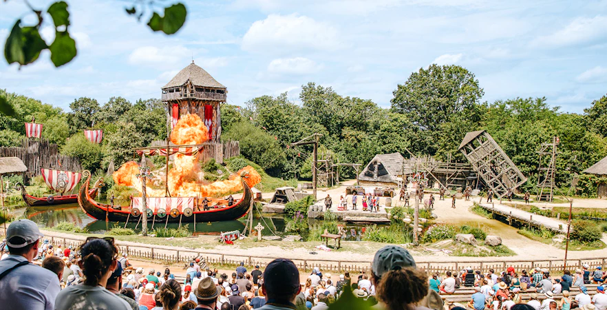 Viking-themed show with fiery explosion at Puy Du Fou, France, viewed by audience.