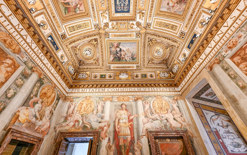 Interior of Castel Sant'Angelo featuring ornate ceiling details and frescoes in Rome, Italy.
