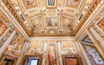 Interior of Castel Sant'Angelo featuring ornate ceiling details and frescoes in Rome, Italy.