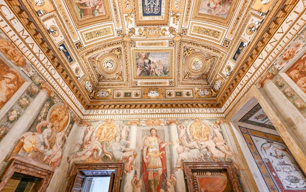 Interior of Castel Sant'Angelo featuring ornate ceiling details and frescoes in Rome, Italy.