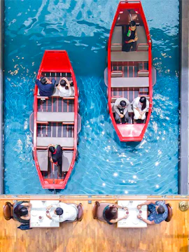 Gondola rides inside Marina Bay Sands, Singapore, with diners seated nearby.