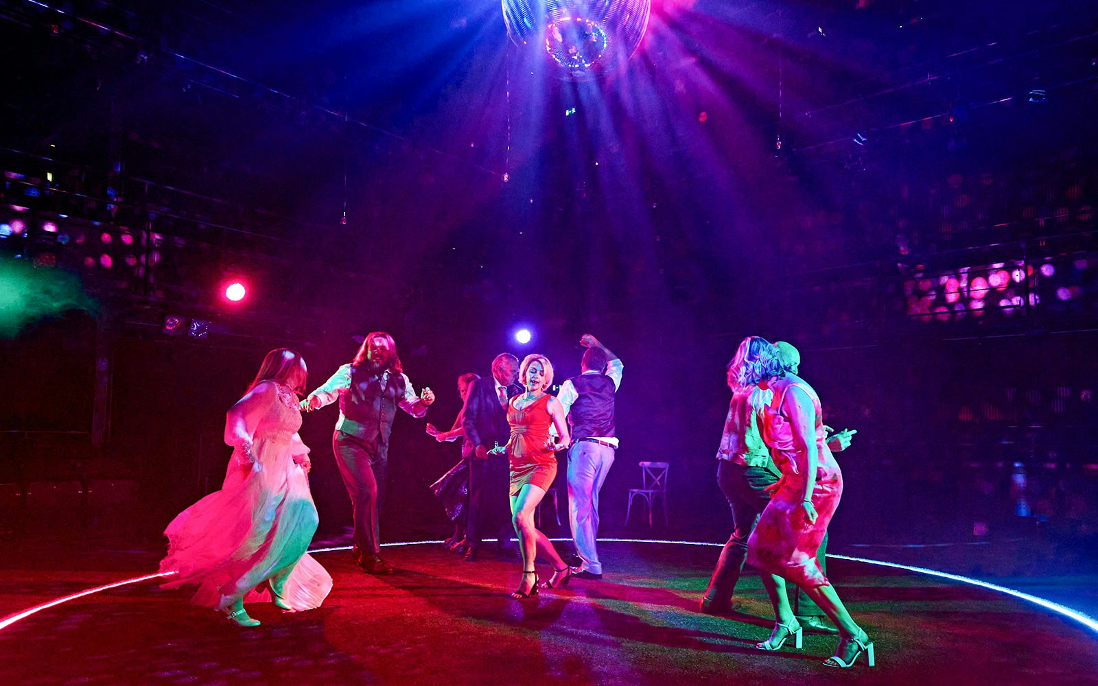 People dancing under colorful lights at a vibrant event, "Till The Stars Come Down.