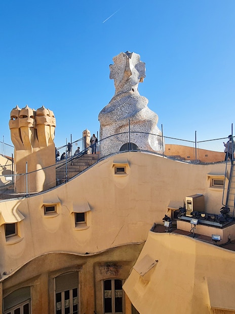 La Pedrera Casa Mila rooftop with unique chimneys and visitors in Barcelona.