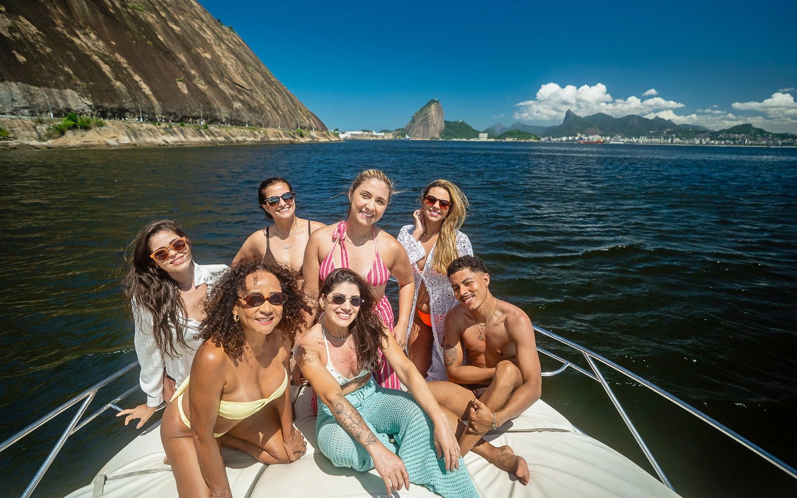Tourists enjoying a boat ride in Guanabara Bay, Rio de Janeiro with Sugarloaf Mountain in the background.