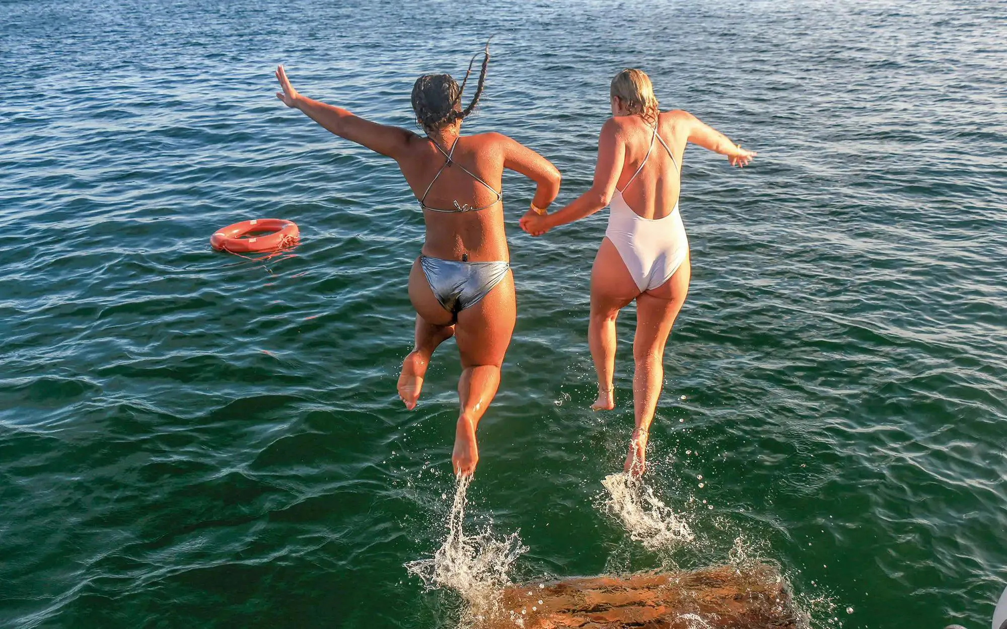Tourists jumping into the sea during Vilamoura brunch and Benagil Caves tour.