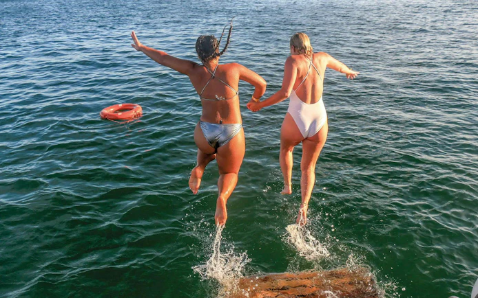 Tourists jumping into the sea during Vilamoura brunch and Benagil Caves tour.