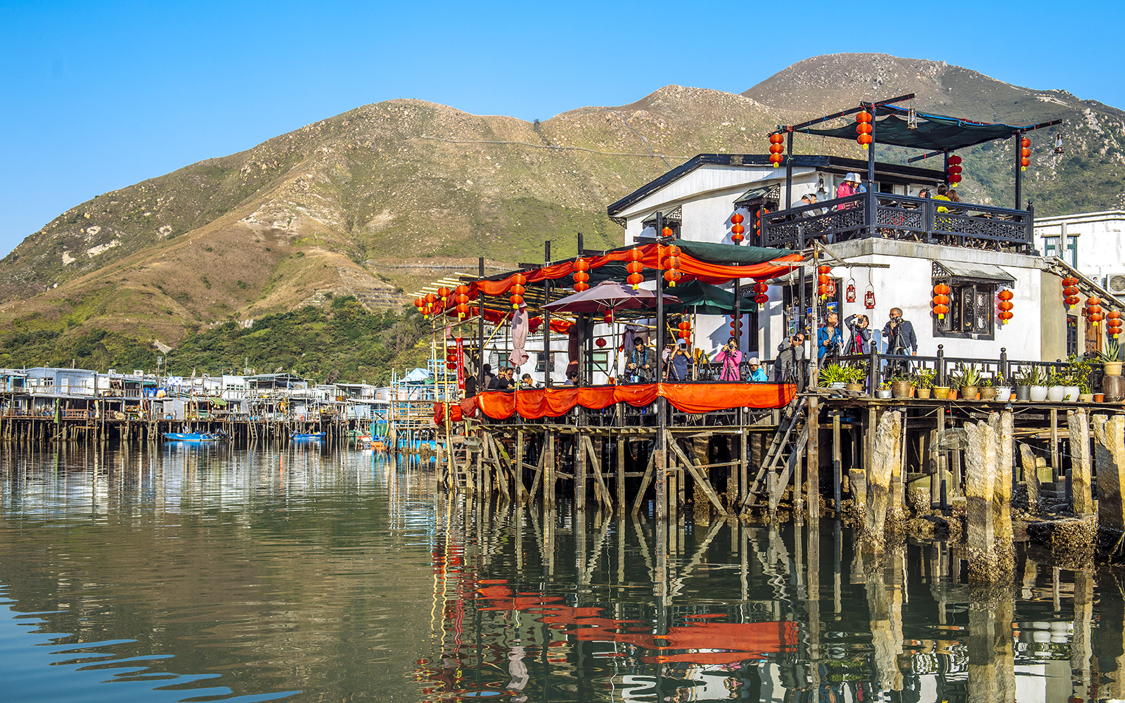 Stilt houses decorated with lanterns on Lantau Island during Ngong Ping Cable Car Ride tour.