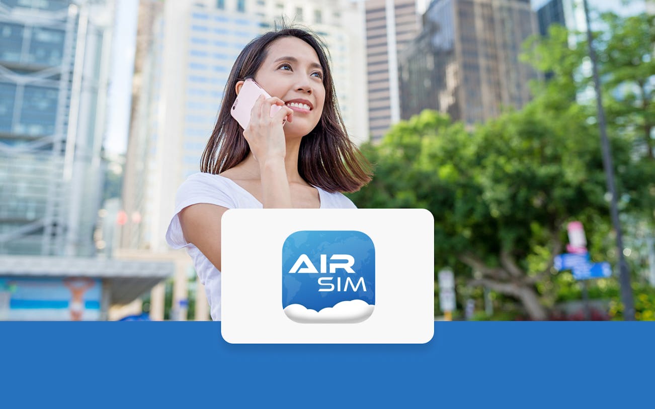 Person using phone with Hong Kong skyline, promoting AIRSIM travel card.
