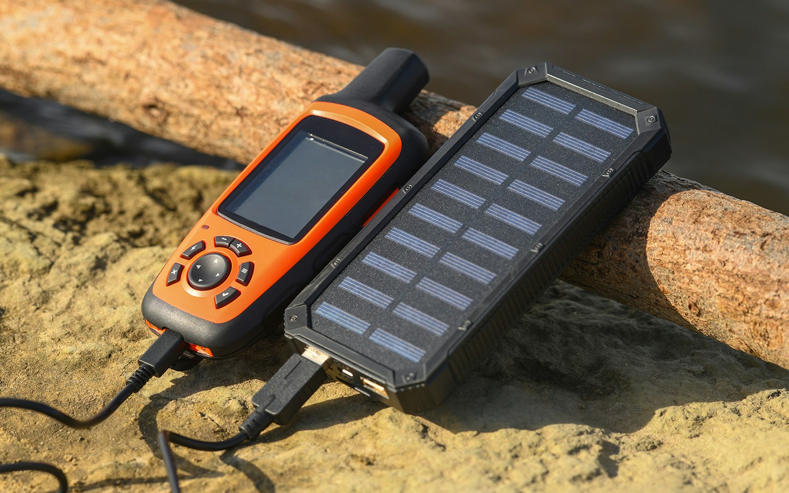 Satellite communicator with GPS and solar power bank charging outdoors.