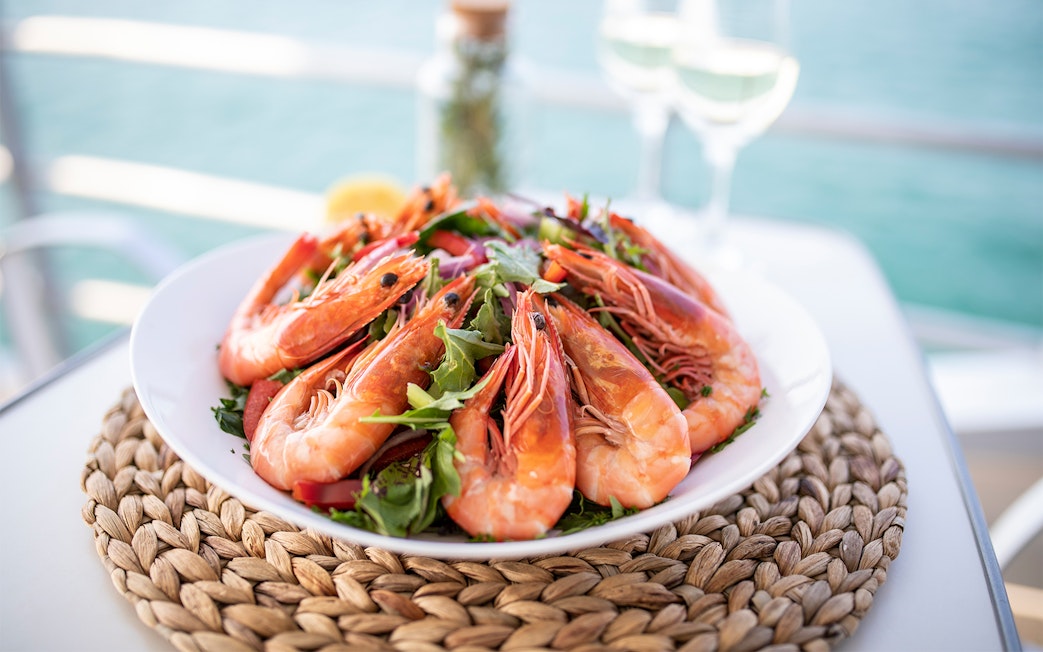 Plate of fresh prawns with greens on Moreton Island tour.
