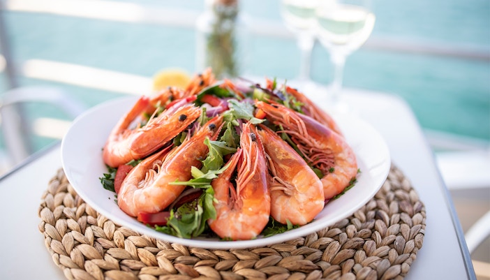 Plate of fresh prawns with greens on Moreton Island tour.