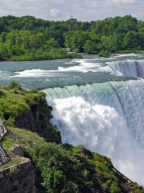 Visitors at Niagara Falls viewpoint overlooking the waterfall and river.