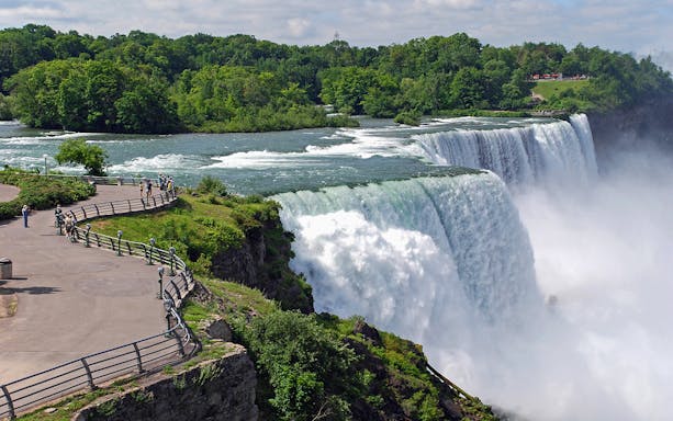 Visitors at Niagara Falls viewpoint overlooking the waterfall and river.