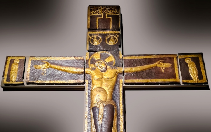Processional Cross at Milan Duomo Museum depicting Christ with outstretched arms.