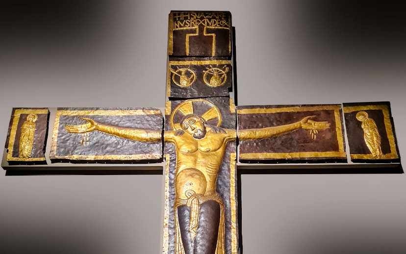 Processional Cross at Milan Duomo Museum depicting Christ with outstretched arms.
