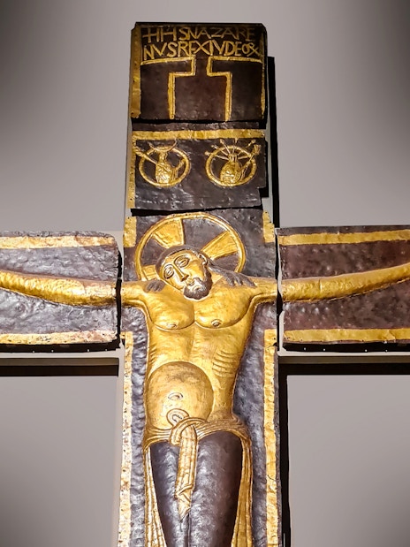 Processional Cross at Milan Duomo Museum depicting Christ with outstretched arms.