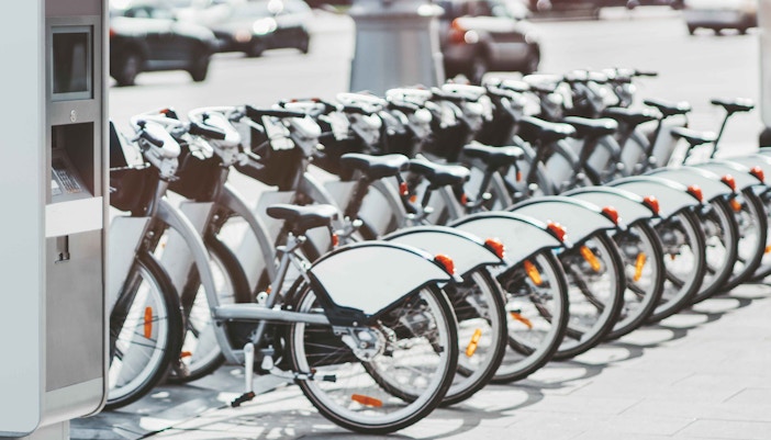 Bike rental station in Lisbon with multiple bicycles lined up.