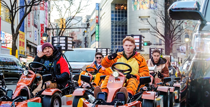 Tourists in costumes driving go-karts on Shibuya streets, Tokyo.