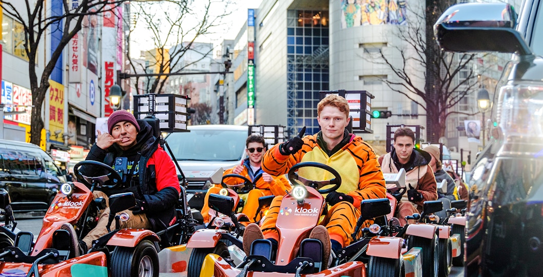 Tourists in costumes driving go-karts on Shibuya streets, Tokyo.