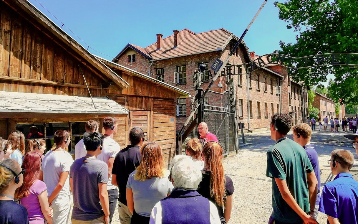 Visitors on a guided tour at the Auschwitz I gate, Poland.