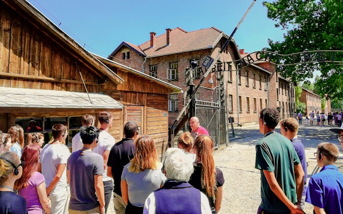 Visitors on a guided tour at the Auschwitz I gate, Poland.