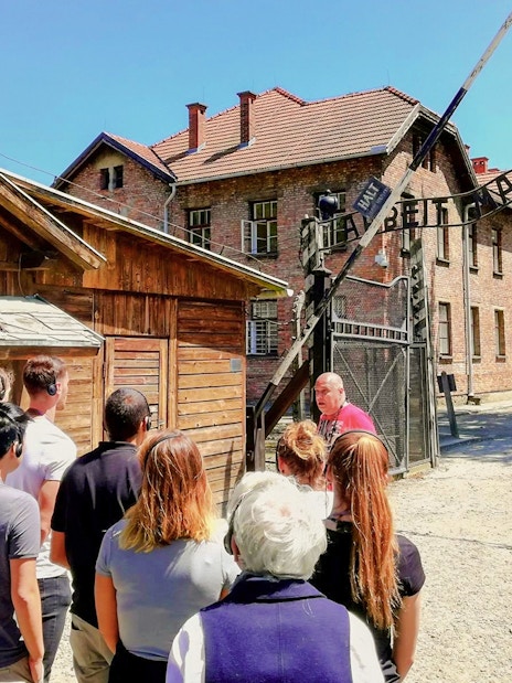 Visitors on a guided tour at the Auschwitz I gate, Poland.