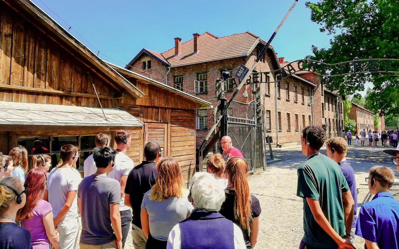 Visitors on a guided tour at the Auschwitz I gate, Poland.