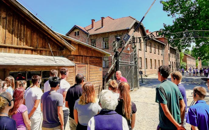 Visitors on a guided tour at the Auschwitz I gate, Poland.