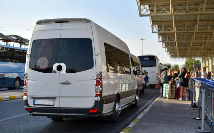 Shuttle buses at Istanbul Airport terminal with passengers boarding.