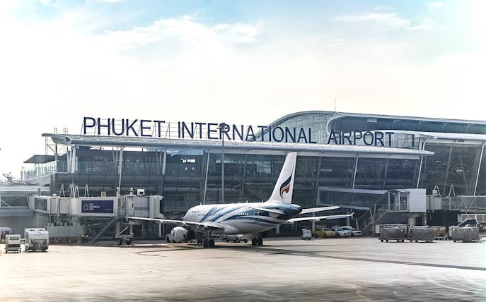Phuket International Airport with airplane on tarmac for last-minute transfers.