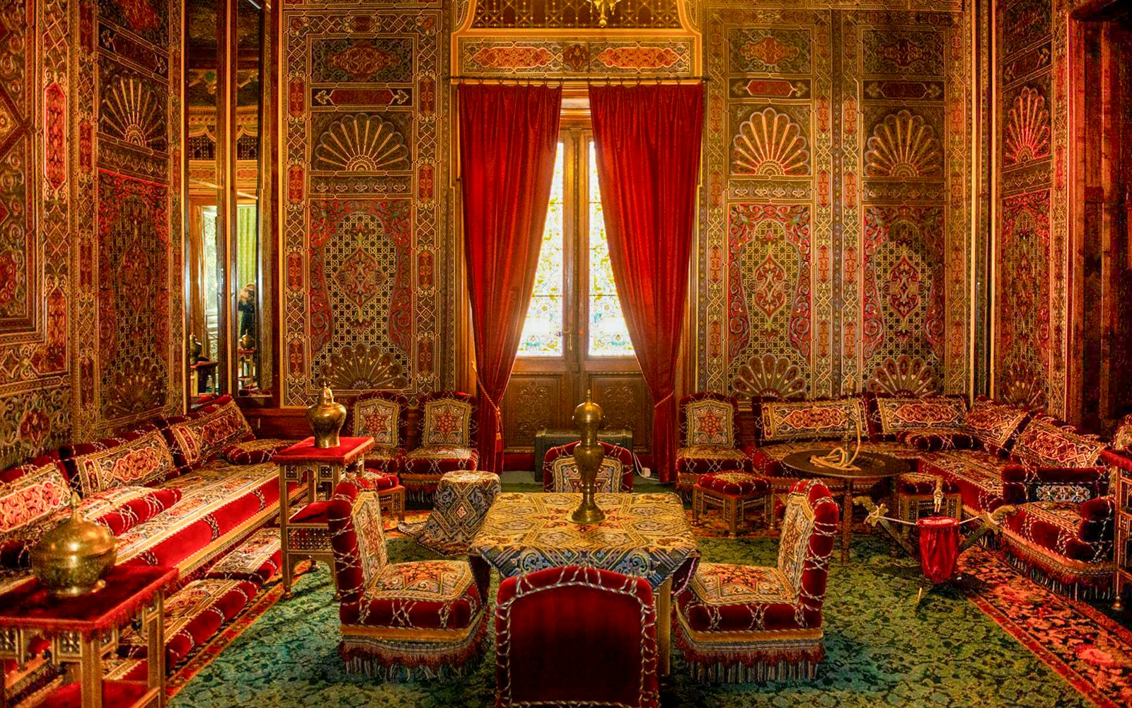Turkish room with ornate decor and red furnishings inside Peles Castle, Romania.