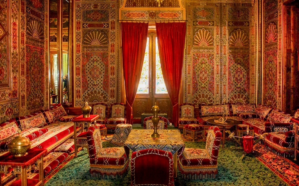 Turkish room with ornate decor and red furnishings inside Peles Castle, Romania.