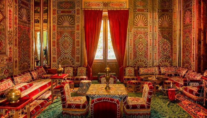 Turkish room with ornate decor and red furnishings inside Peles Castle, Romania.