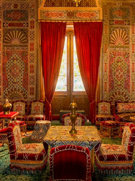 Turkish room with ornate decor and red furnishings inside Peles Castle, Romania.