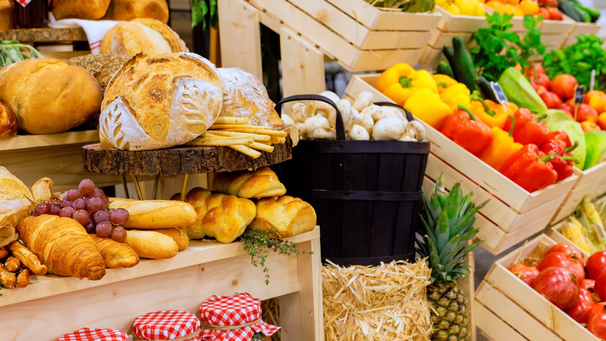 Farmers market display with colorful fruits, vegetables, and freshly baked bread.